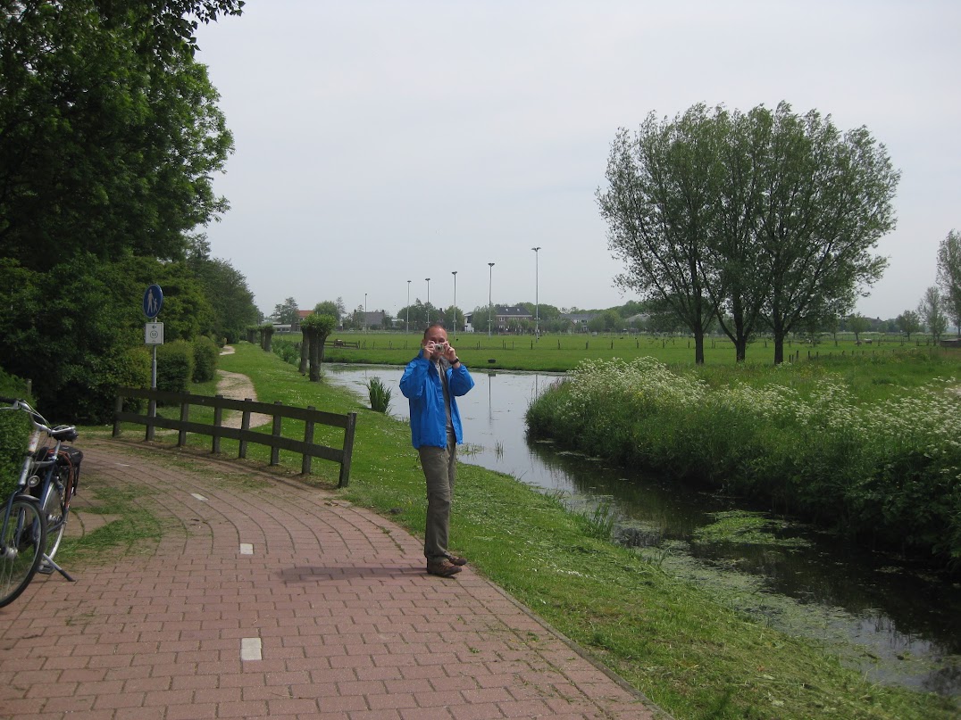 A person beside a tree-lined canal